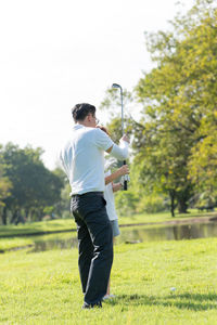 Full length of couple playing golf on field