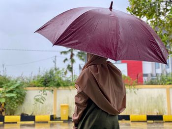 Man holding umbrella standing during rainy season