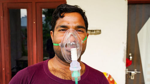 Young boy infected with covid 19 disease. patient inhaling oxygen wearing mask with liquid oxygen 
