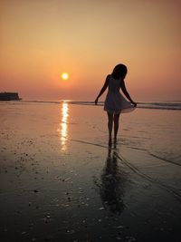 Silhouette of people on beach at sunset