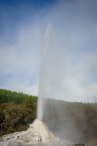 Scenic view of waterfall against sky