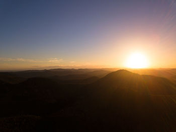 Scenic view of silhouette mountains against sky during sunset