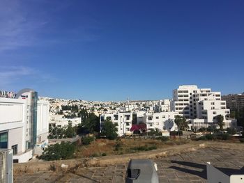 Buildings in city against clear blue sky