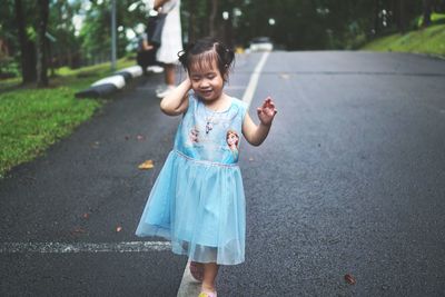 Full length of cute girl walking on road