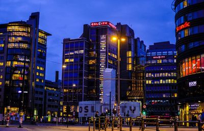 Low angle view of illuminated cityscape against sky at night