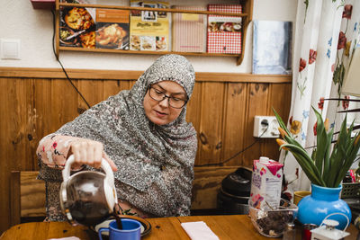 Woman pouring coffee in cup