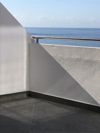 View of concrete wall by sea against sky