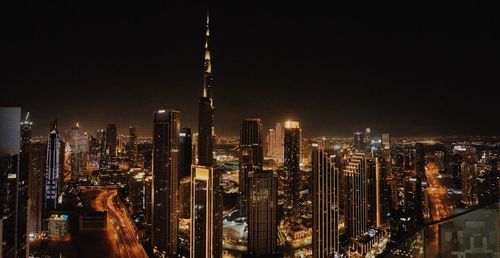 Illuminated cityscape against sky at night