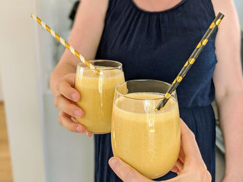 Midsection of woman drinking glass