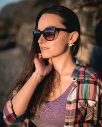 Woman looking away wearing sunglasses while standing outdoors