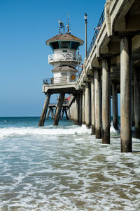 Lifeguard hut on beach by sea against clear sky