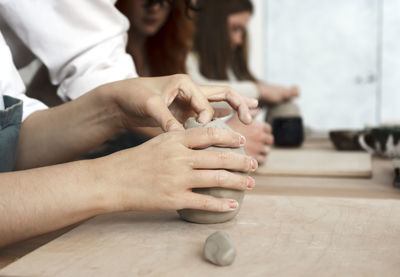 Woman's hands sculpt from a clay. pottery workshop class.