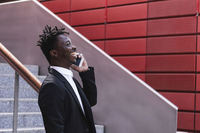 Young man looking away against brick wall