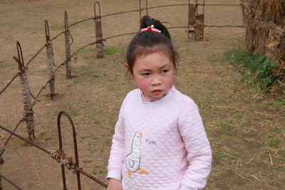 Portrait of cute boy standing on field