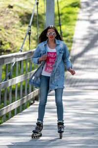 Full length of young woman standing on railing