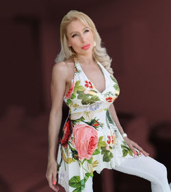 Portrait of a beautiful young woman standing against red wall