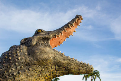 Low angle view of animal sculpture against sky