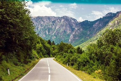 Empty road along countryside landscape