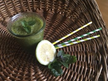 High angle view of drink with lemon and basil in basket