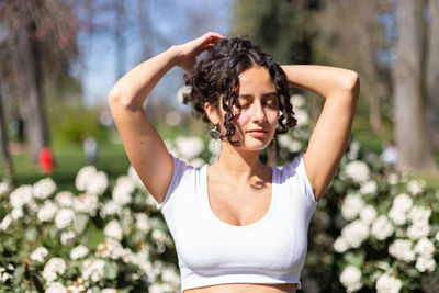 Young woman with curly hair in the park enjoying the sunshine