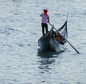 Gondolier sailing on gondola over grand canal