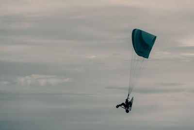 Low angle view of person paragliding against sky