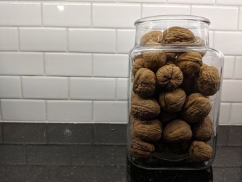 Close-up of bread in jar on floor against wall