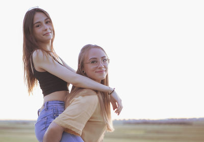 Two women holding hands at sunset in the field