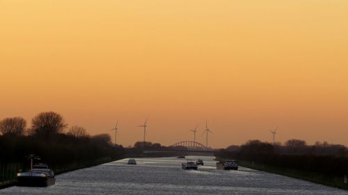 Cars on road against sky during sunset