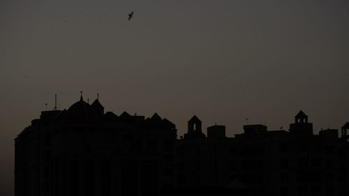 Low angle view of silhouette buildings against sky at dusk