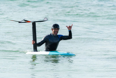 Portrait of man with sports equipment in sea