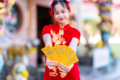 Portrait of smiling girl holding envelopes