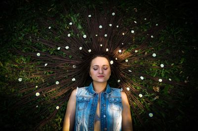 High angle view of woman with brown hair lying on grassy field