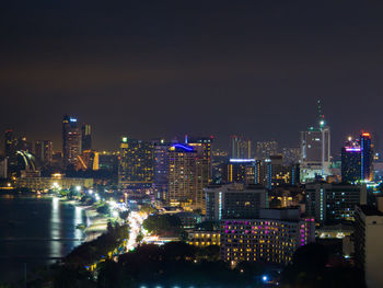 Illuminated buildings in city against sky at night