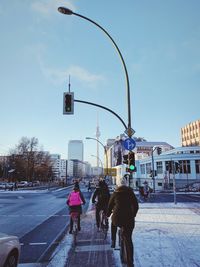 People on road in city against sky