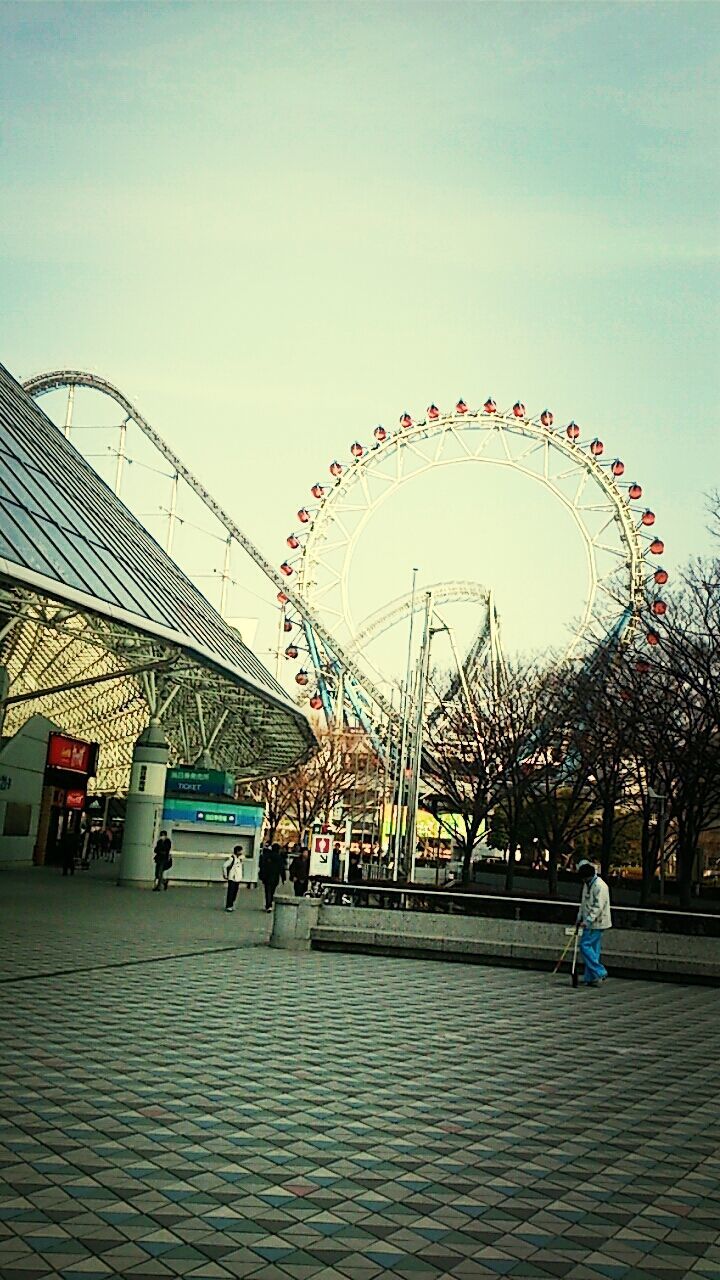 amusement park, leisure activity, ferris wheel, arts culture and entertainment, amusement park ride, men, lifestyles, sky, built structure, person, architecture, tree, large group of people, enjoyment, incidental people, walking, outdoors, silhouette, medium group of people