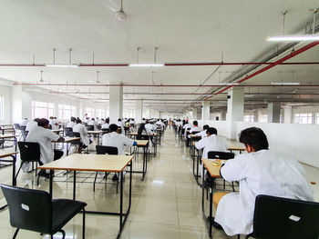 Rear view of people sitting on table