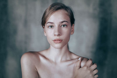 Close-up of young woman against wall