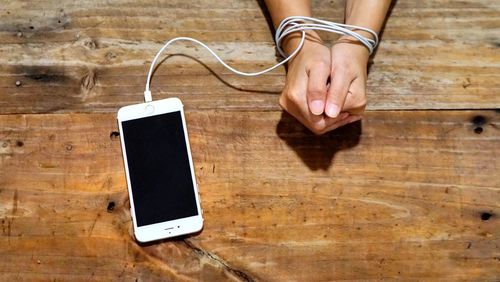 Low section of person using smart phone on table