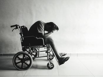 Tensed man sitting on wheelchair at home