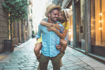 Happy friends standing on street in city