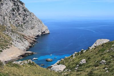 High angle view of sea by mountains against sky