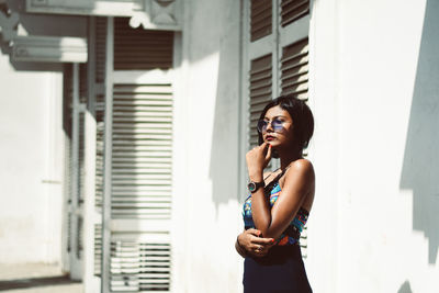 Full length of woman standing against wall