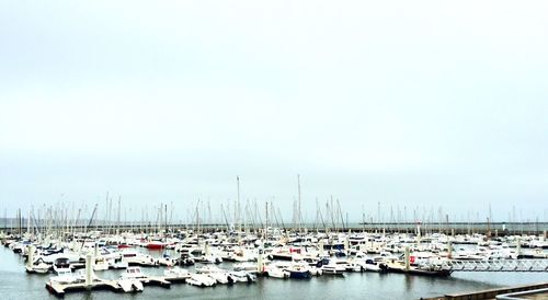 Boats at harbor against sky