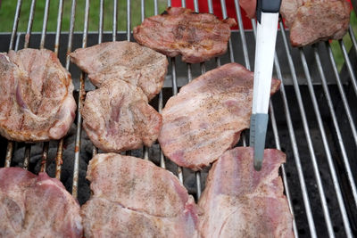 High angle view of meat steaks on barbeque grill