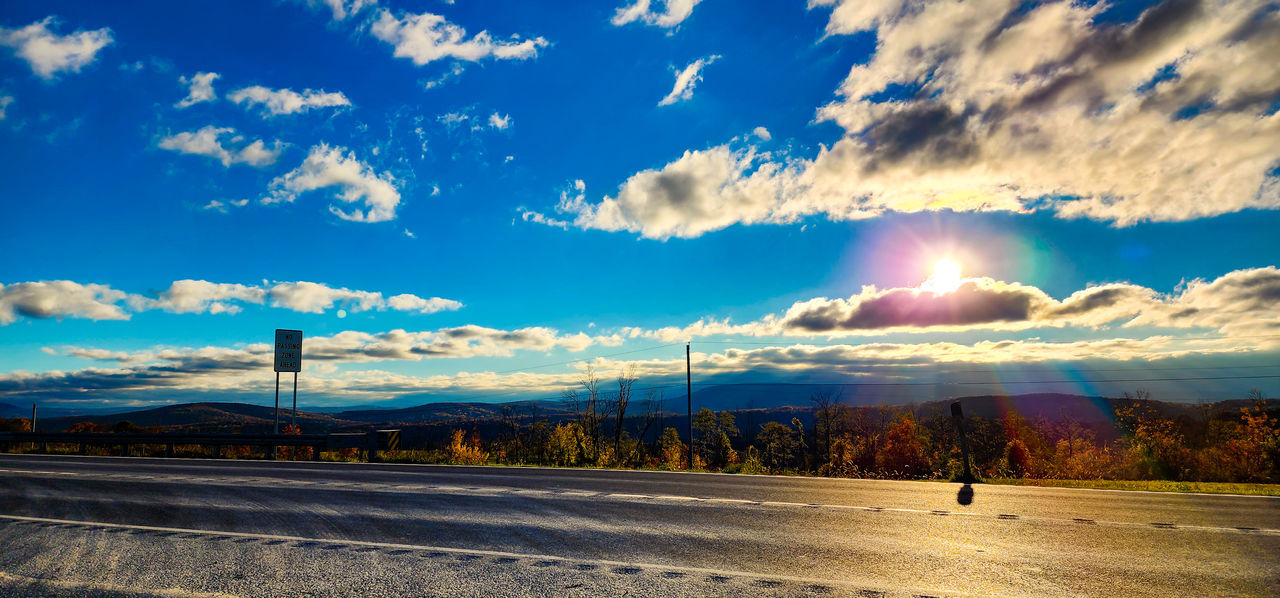 sky, horizon, cloud, dusk, landscape, environment, evening, road, sunlight, nature, sunset, scenics - nature, beauty in nature, transportation, mountain, land, travel, panoramic, blue, travel destinations, tranquility, no people, sun, outdoors, dramatic sky, tree, tranquil scene, street, city, plant, reflection, cloudscape, highway, rural scene, idyllic