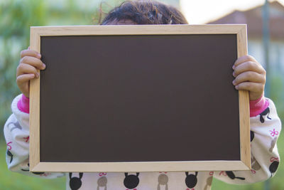 Close-up of girl holding slate