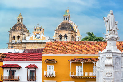 Low angle view of statues with iglesia de san pedro claver against sky