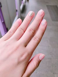 Cropped hand of woman showing painted fingernails