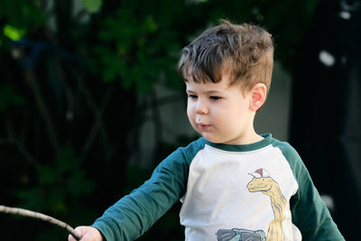 Boy playing with a stick in the garden